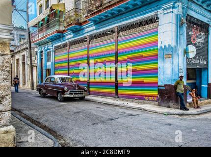 Havanna, Kuba, Juli 2019, burgunderfarbenes Chevrolet-Auto, das vor dem Wandgemälde `Love `geparkt ist, das der Straßenkünstler Robin Pedraj auf einem Rollladen gemalt hat Stockfoto